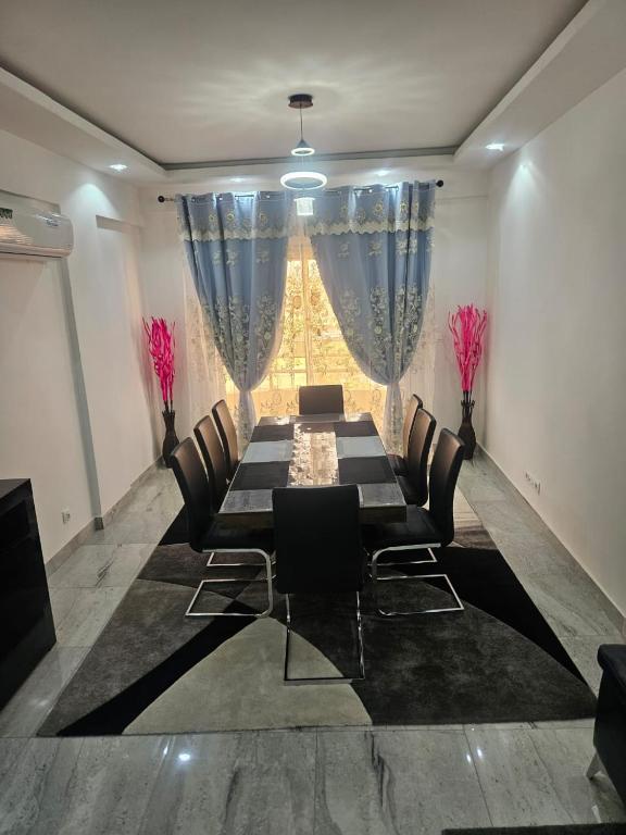 a dining room with a table and chairs and a window at Mimi in Dakar