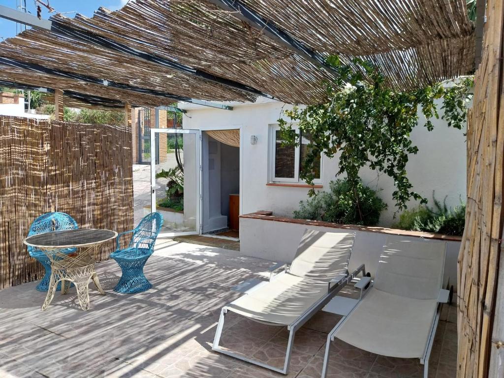 a patio with a table and two chairs and a table at Casa Papaver Casita in Coín