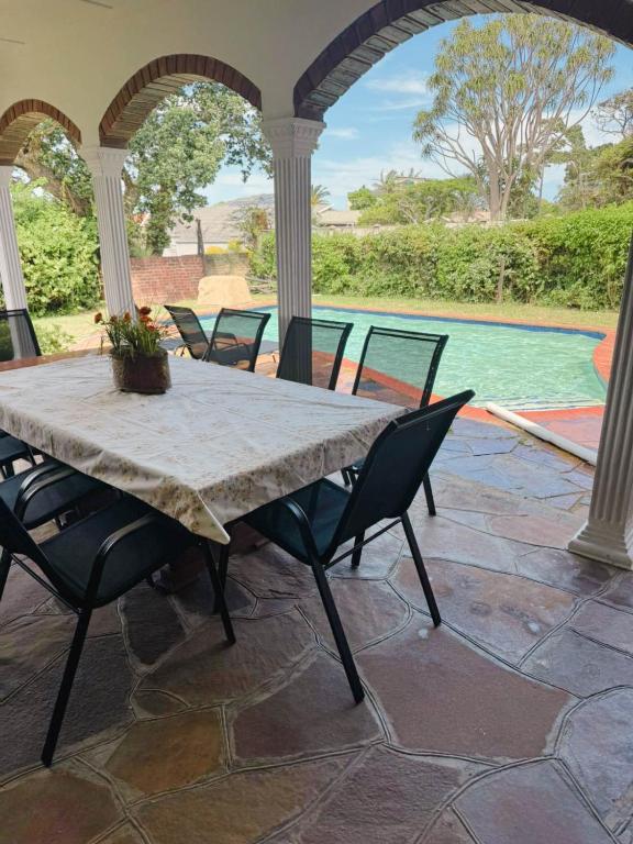 a table and chairs on a patio with a pool at Preston House in Park Rynie