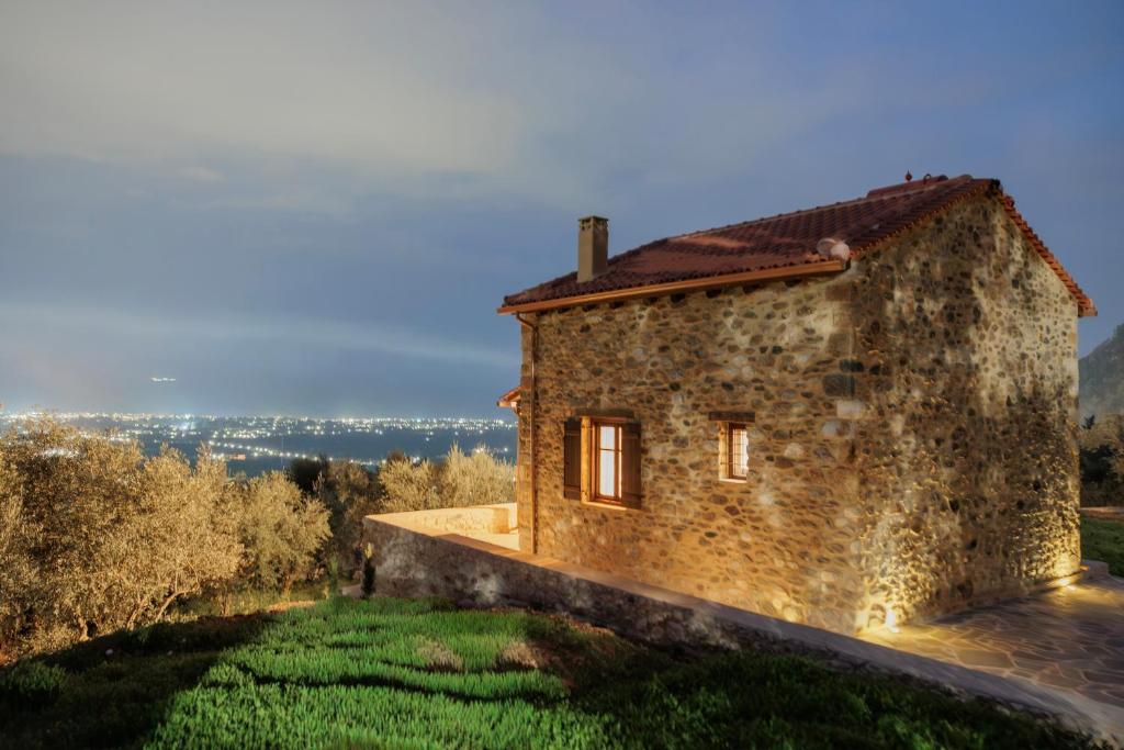 a stone house on a hill with green grass at Mystras Panorama House in Mystras