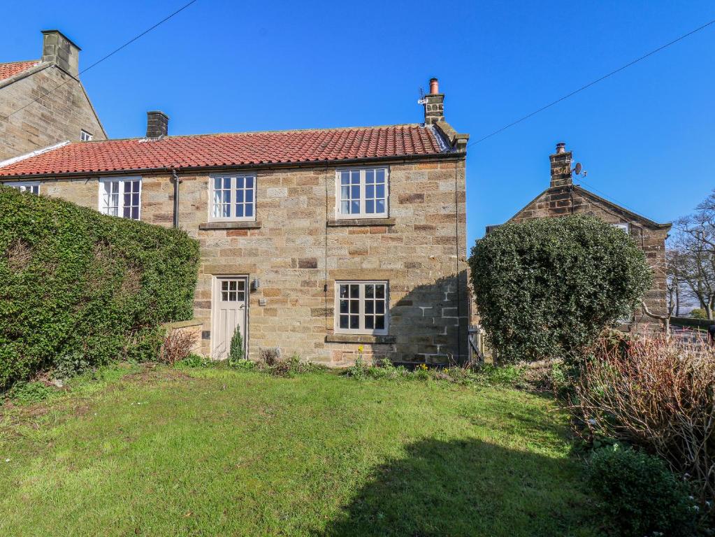 an old stone house with a red roof at Holly Cottage in Whitby