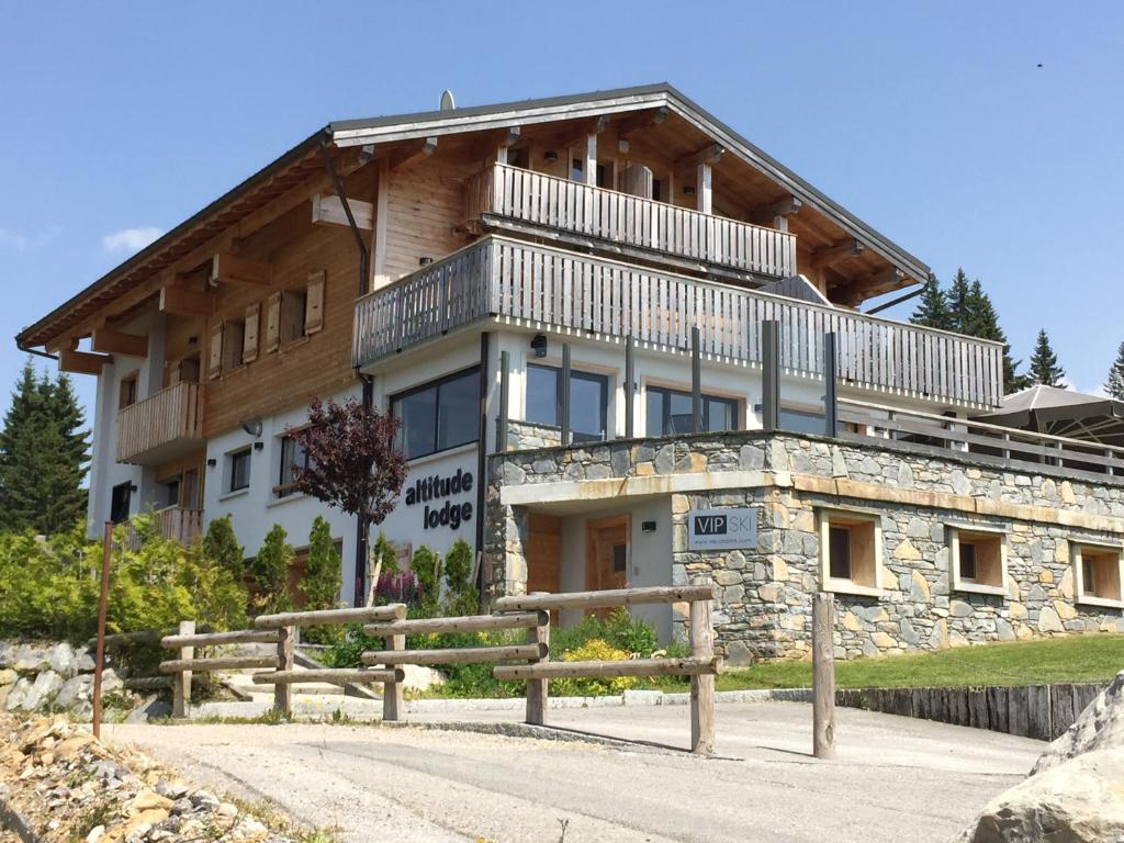 - un grand bâtiment avec un balcon en haut dans l'établissement Altitude Lodge, aux Gets