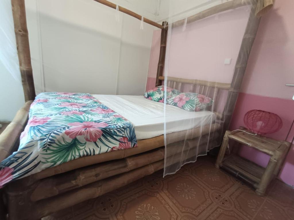 a bed with a canopy in a room at Ma case créole in Port-Louis