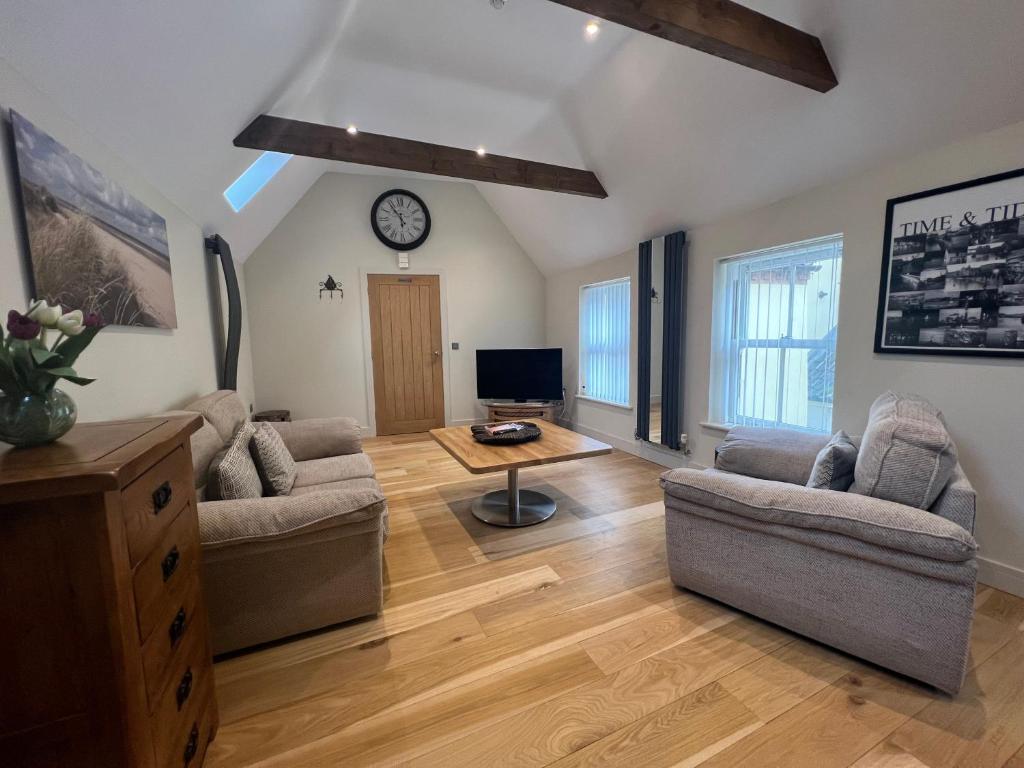 a living room with a couch and a table at Heron's Hideaway in Wells next the Sea