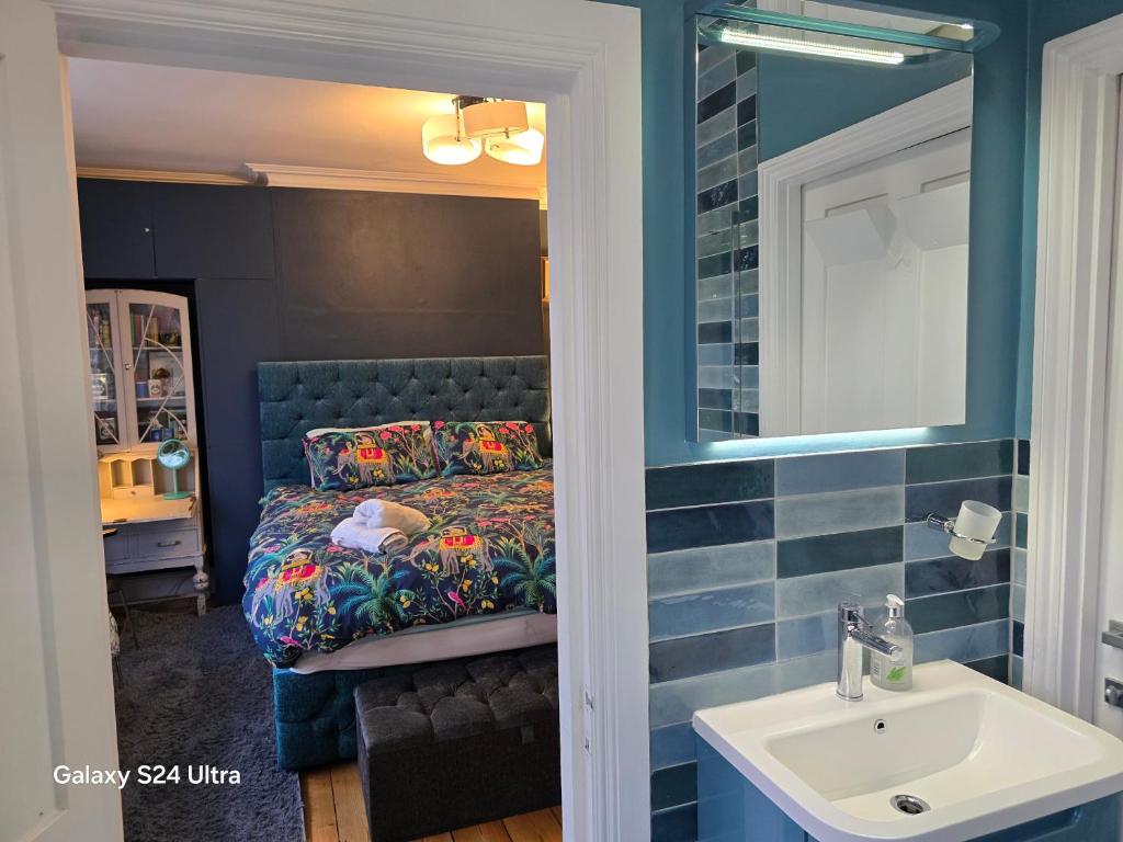 a bathroom with a bed with a sink and a mirror at Great Central self-contained flat in Cambridge