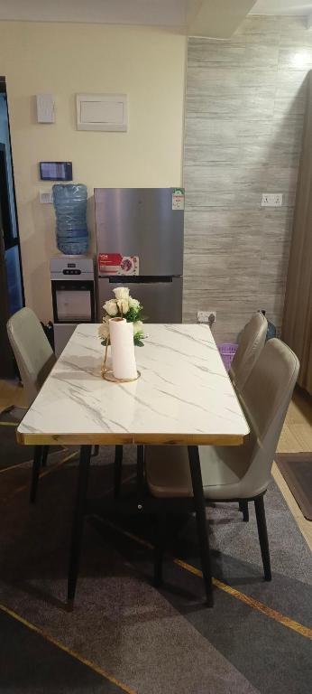 a table with chairs around it with flowers on it at Hillary homes in Nairobi
