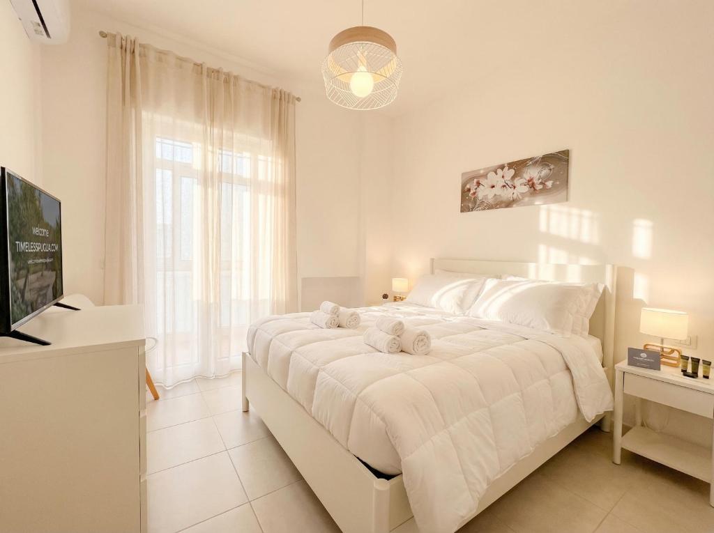 a white bedroom with a large bed and a television at LARI - appartamento moderno in centro in Bari