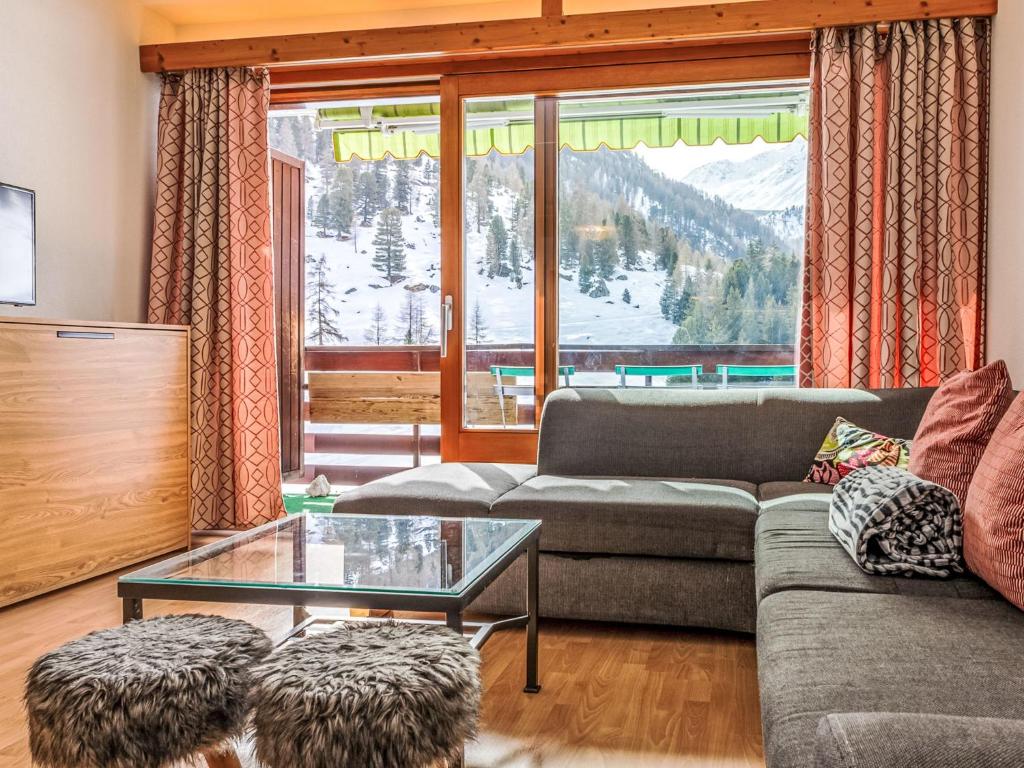 a living room with a couch and a glass table at Apartment Rosablanche D31 by Interhome in Siviez