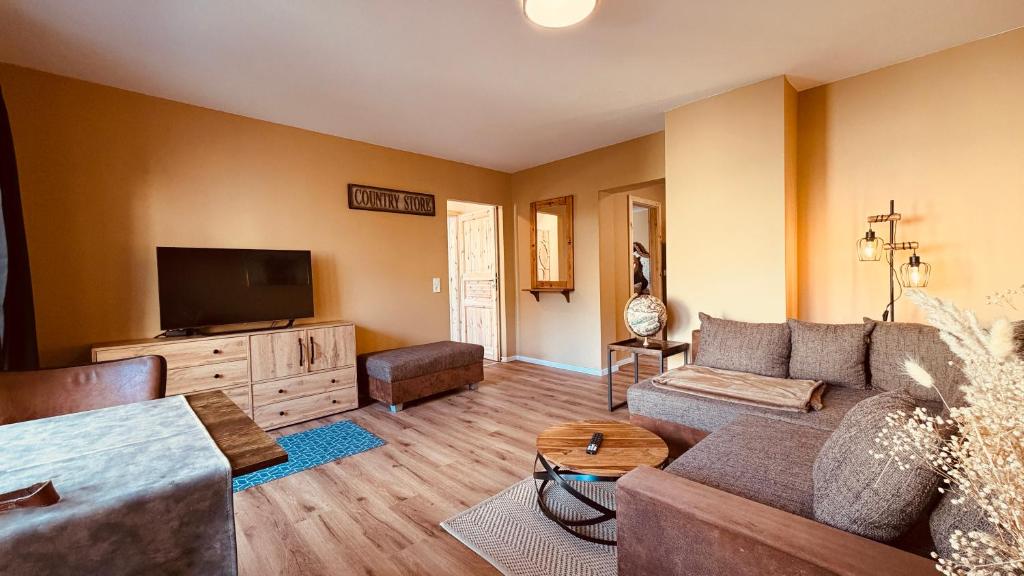 a living room with a couch and a flat screen tv at Fabians Ferienhaus Rursee Rusti in Simmerath