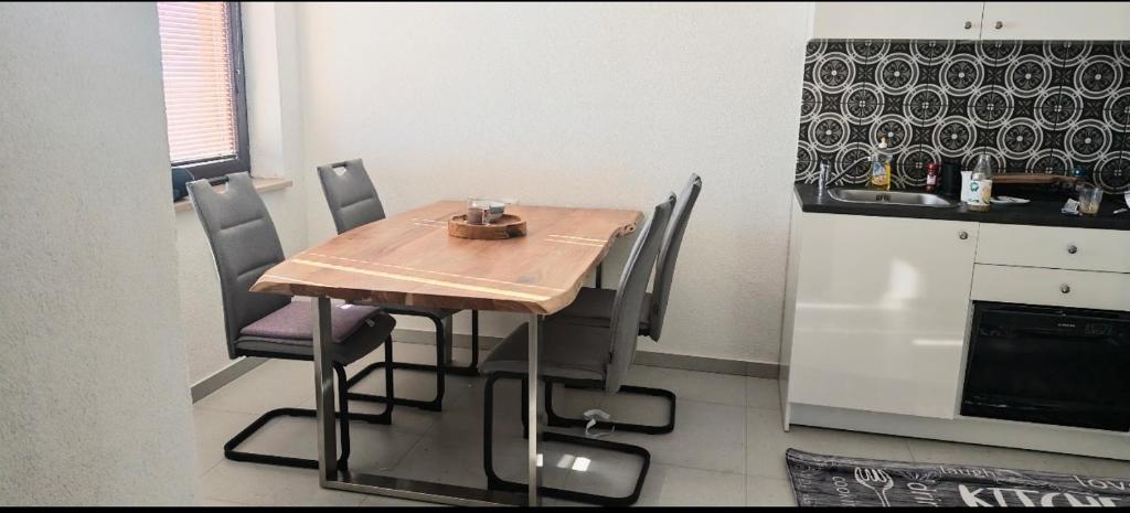 a kitchen with a wooden table and chairs and a refrigerator at Smit apartman in Novi Vinodolski