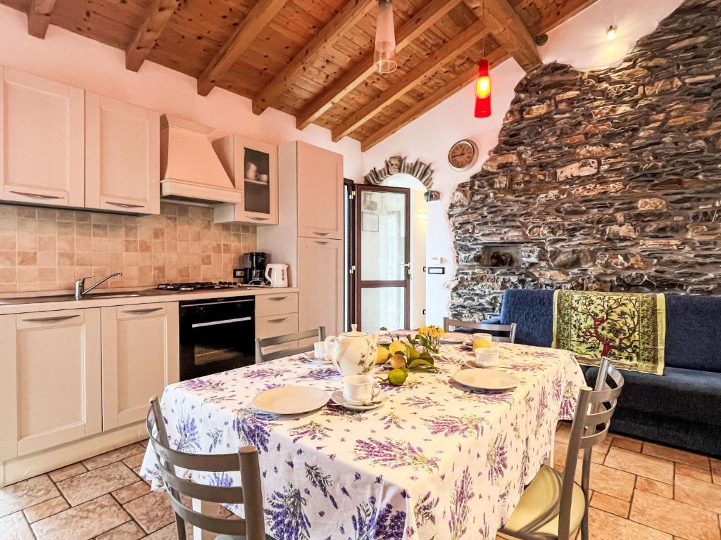 a dining room with a table and a kitchen at Holiday Home Ca' da Ciassa - Prima Porta - VLO132 by Interhome in Pantasina