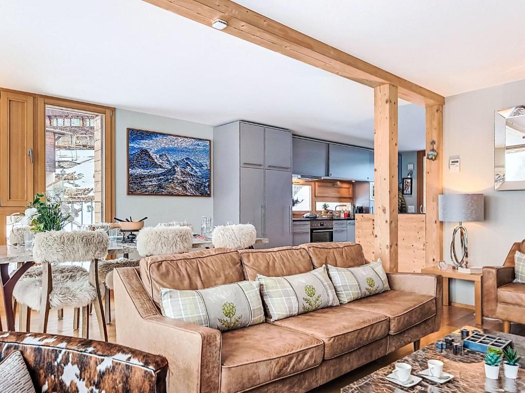 a living room with a couch and a kitchen at Apartment Roossi Apt- 1 by Interhome in Wengen