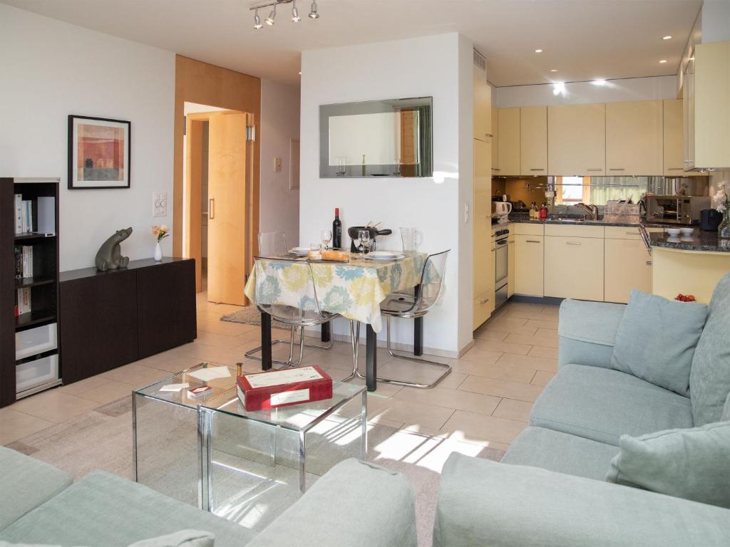 a living room with a table and a kitchen at Apartment Bella Vista Apt- No- 09 by Interhome in Wengen
