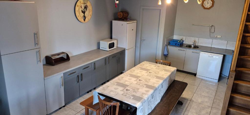 a kitchen with a table and a white refrigerator at gite climatisé jusqu'à 9 personnes secteurs la broque Obernai Strasbourg in La Broque
