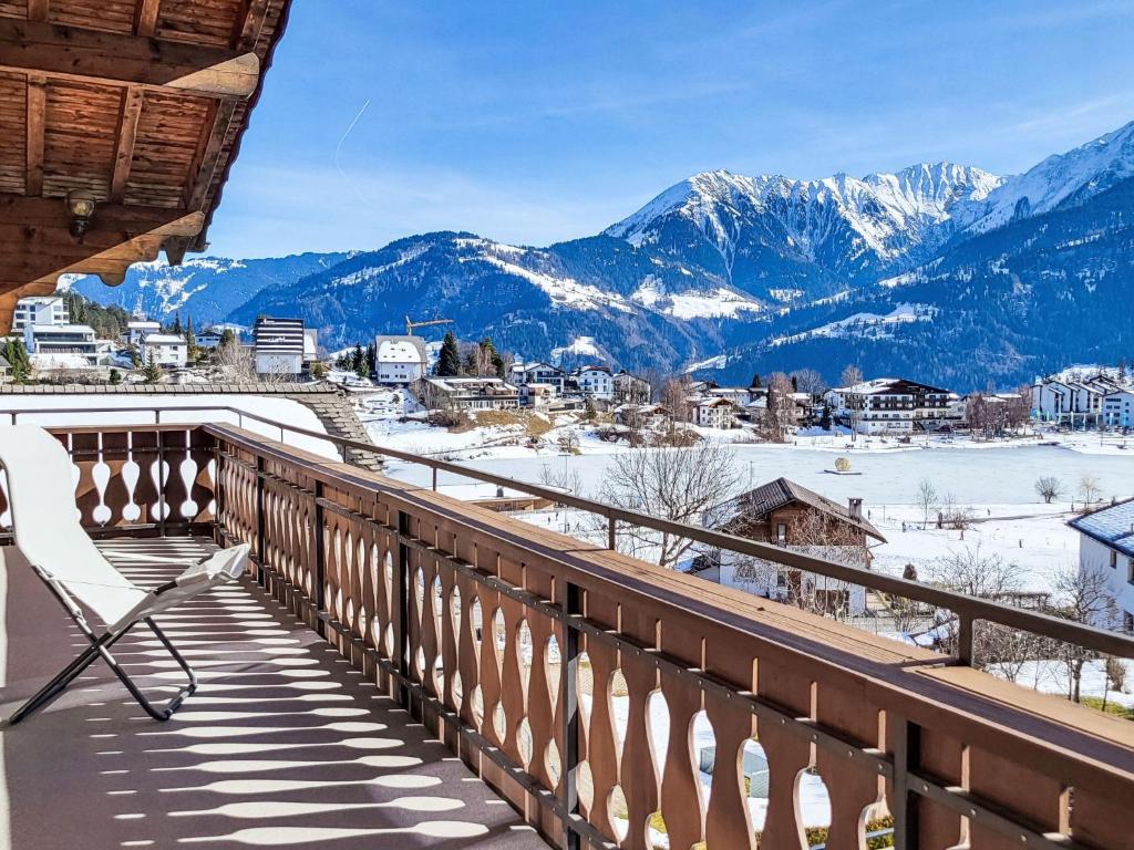 a chair on a balcony with a view of mountains at Apartment Chalet mit Bergsicht by Interhome in Laax