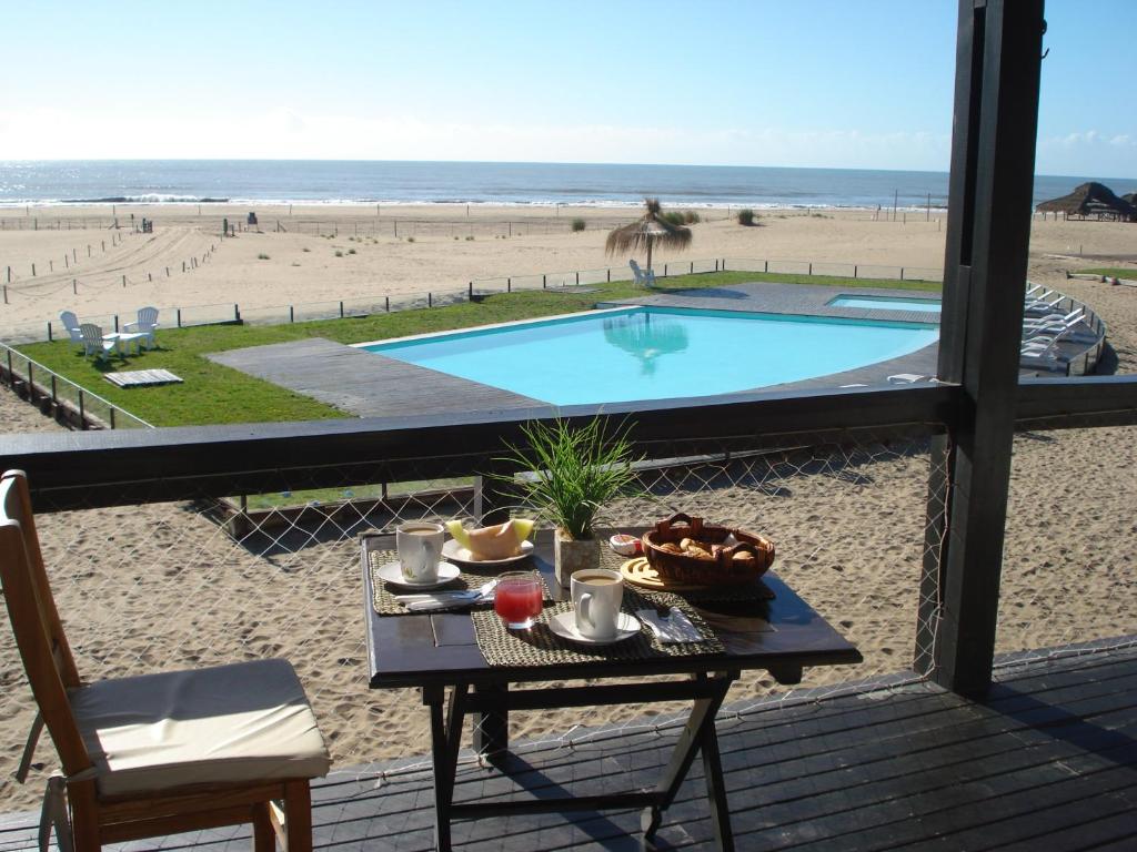 a table on a deck with a view of the beach at Chacras del Mar in Mar Azul