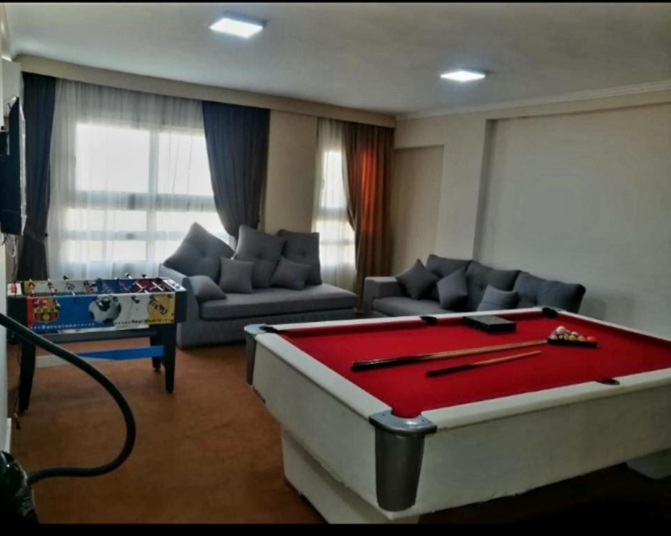a living room with a large red pool table at Ibiza beach apartments in Alexandria
