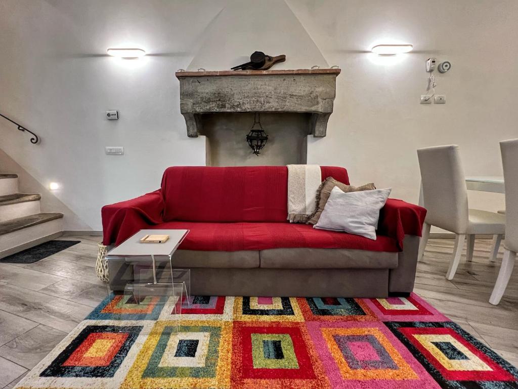 a red couch in a living room with a fireplace at Tolletta 10 e Lode in Arezzo