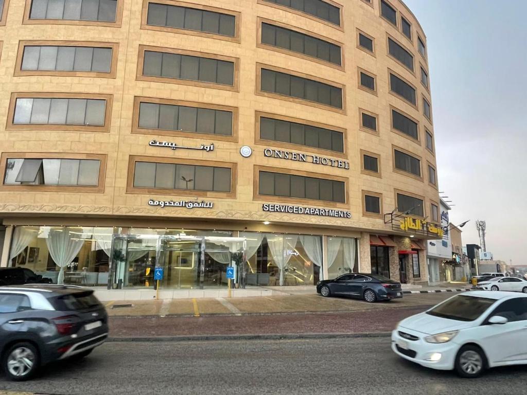 a large building with cars parked in front of it at اونيسن البري Onesn Albari in Unayzah