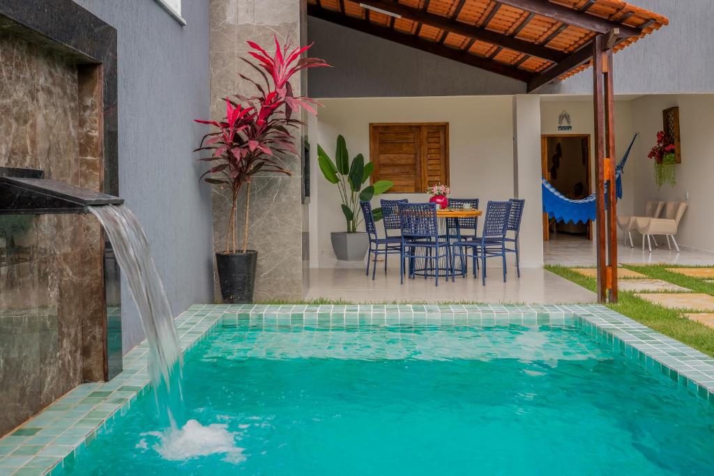 a swimming pool with a waterfall in a house at Renner Ventos praia do Preá Casa Completa com Piscina in Cruz