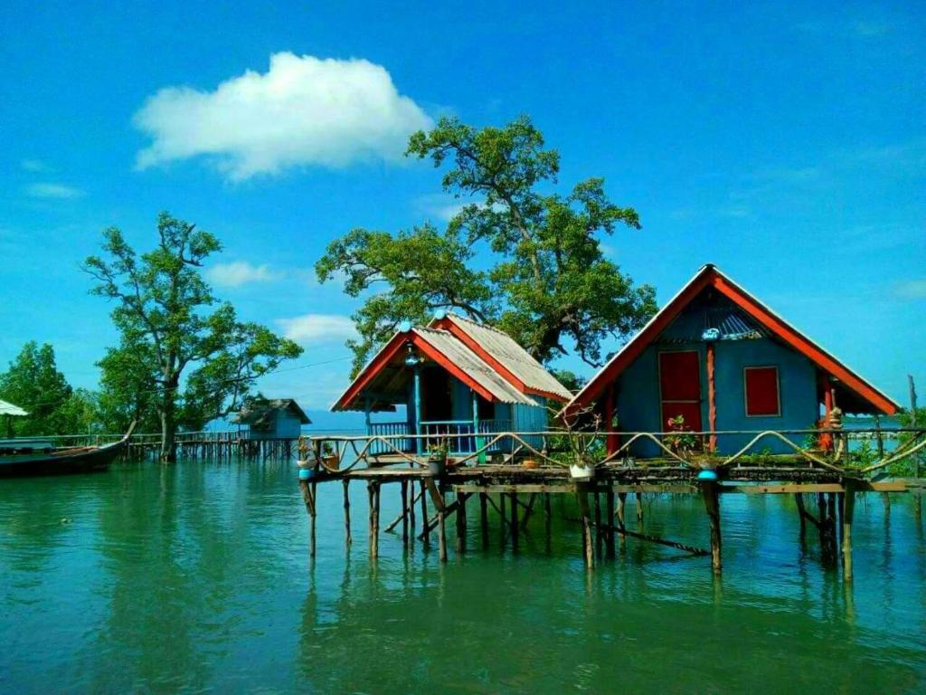 a group of houses on a dock in the water at บากันใหญ่โฮมสเตย์ in Ban Ba Kan Yai