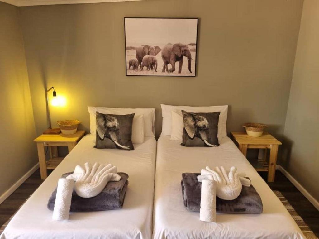 a room with two beds with towels on them at Betta Lodge in Duwisib