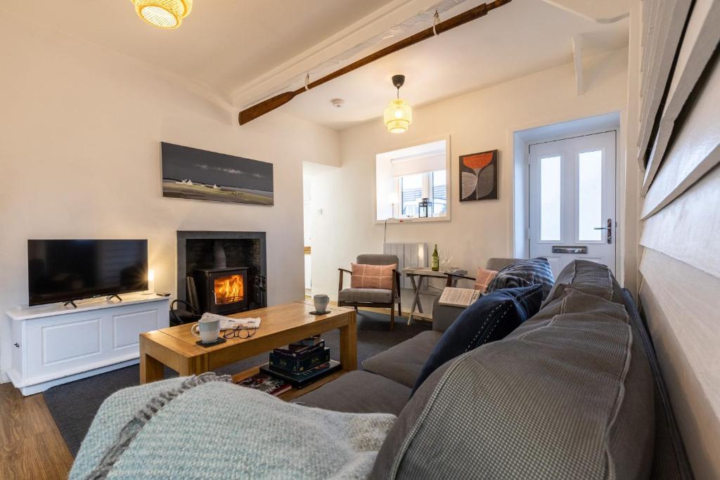 a living room with a couch and a fireplace at Ty Capel Bach in Bodorgan
