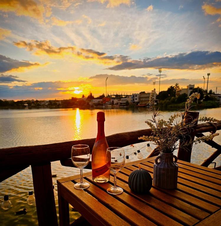 a bottle of wine sitting on a table with two glasses at Domček na vode 6 in Senec