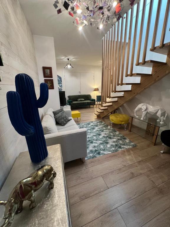 a living room with a couch and a cactus at Idéal groupe tarif long séjour maison 4chambres 8lits 2salles de bain 3wc terrasse stationnement gratuit in Valenciennes