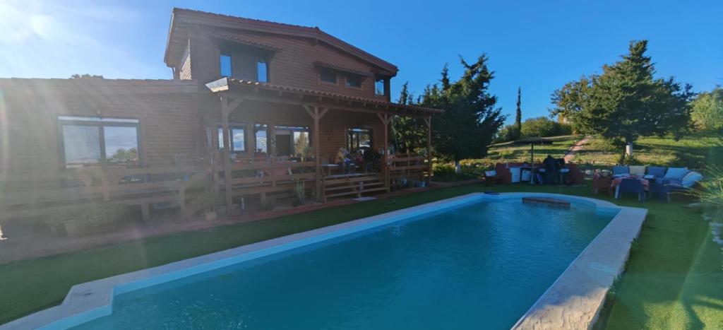 a house with a swimming pool in front of a house at The Lodge apartment in Mesongi