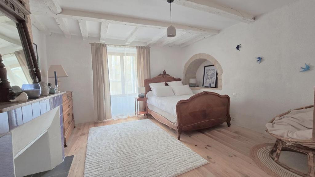 a bedroom with a bed and a large window at L'Hirondelle in Airvault