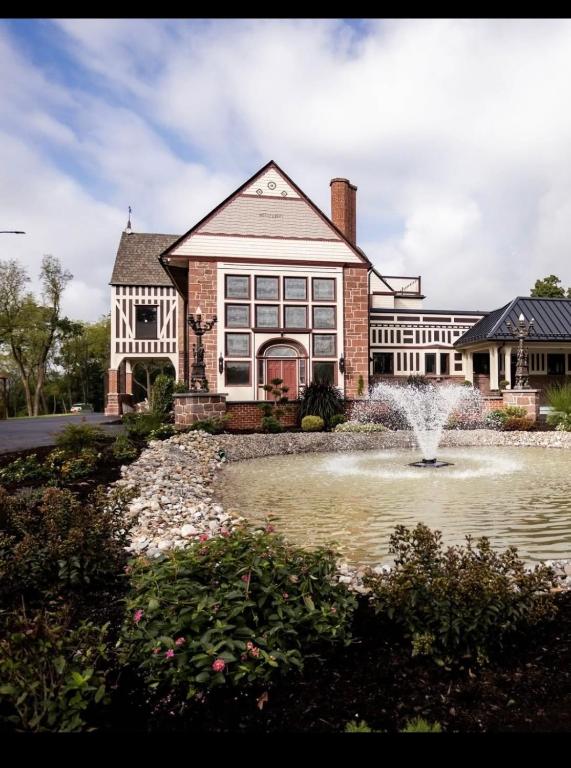 a large house with a fountain in front of a pond at Alden Villa in Lebanon