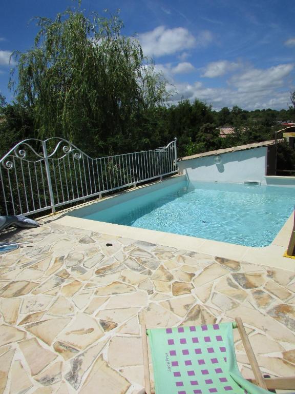 a swimming pool with a chair and a table and a chair at Le Cigalou gîte calme proche Gorges de l' Ardèche & piscine in Gras