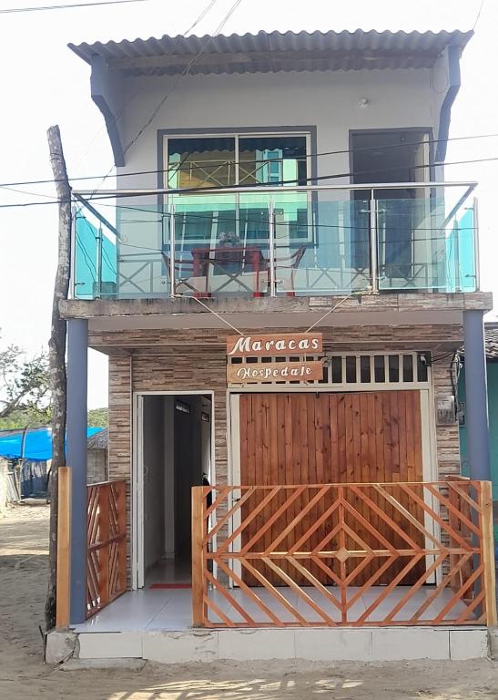 a house with a balcony on top of it at Maracas Hospedaje in Rincón