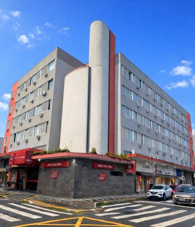 a large building with cars parked in front of it at Antico Plaza Hotel in Taubaté
