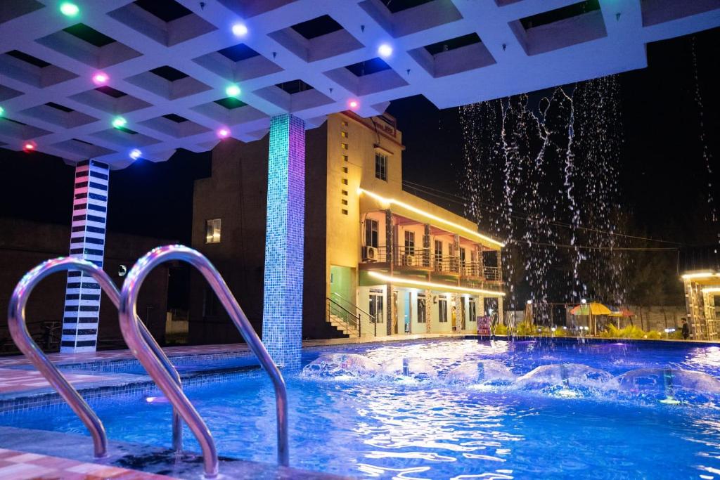 a swimming pool at night with lights at Sea Smile Inn in Mandarmoni