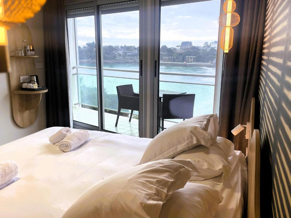 a bedroom with a bed with a view of the ocean at Best Western Hotel Le Crystal Dinard in Dinard