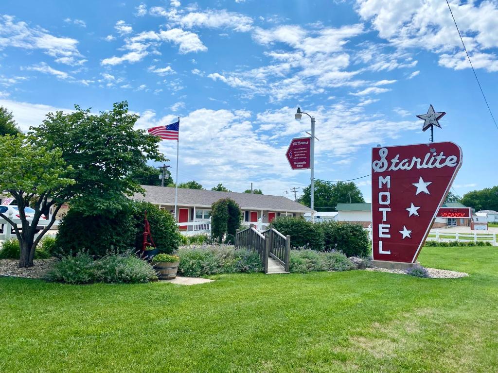 a sign for a hotel with flags in a yard at Starlite Motel in Seneca