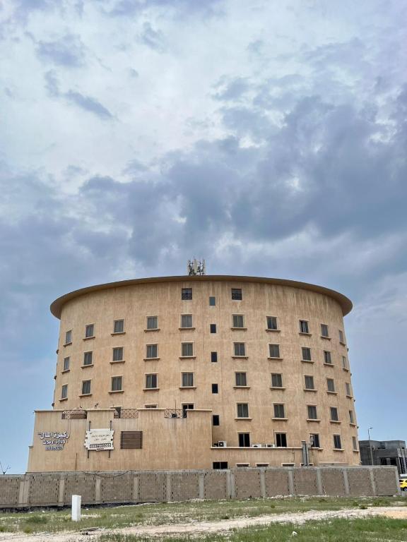 a large round building in front of a cloudy sky at صفاء المسكن in Dammam