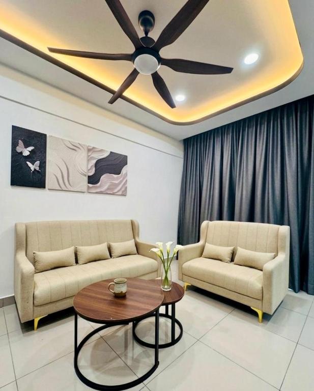 a living room with two couches and a ceiling fan at Cloud Nine Homestay in Tanah Rata