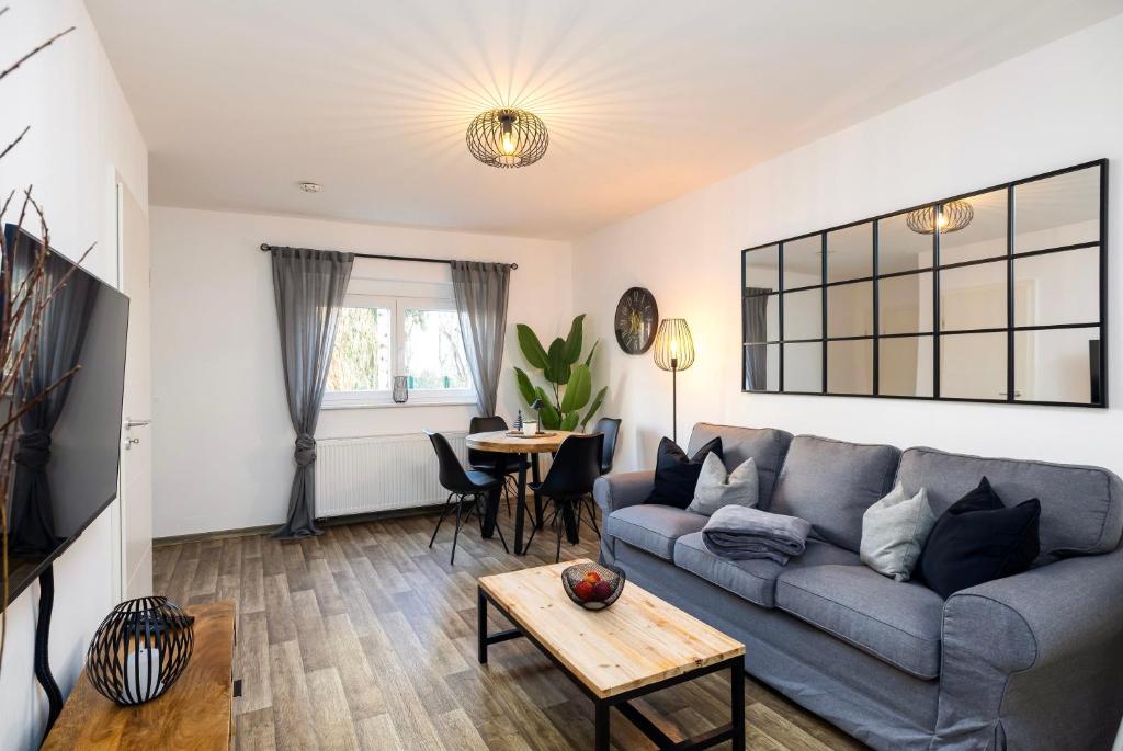 a living room with a couch and a table at Gemütliches & ruhiges Apartment mit Terrasse, Garten & privatem Stellplatz in Dresden