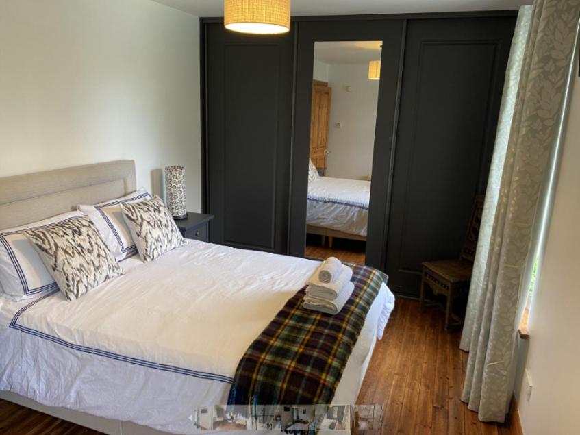 a bedroom with a white bed with a mirror at Room Stay 3 in Ballinhassig