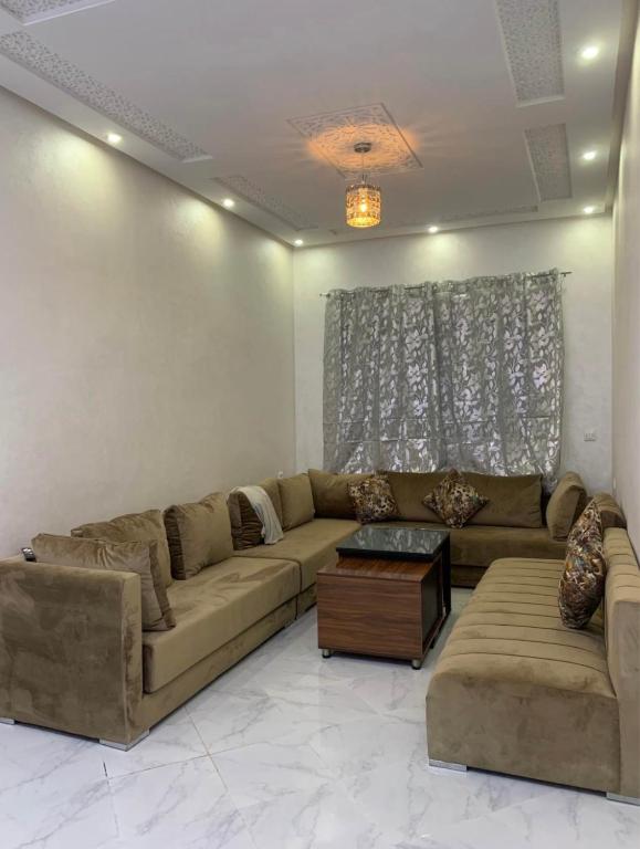 a living room with a couch and a table at Appartement dans quartier calme in Agadir