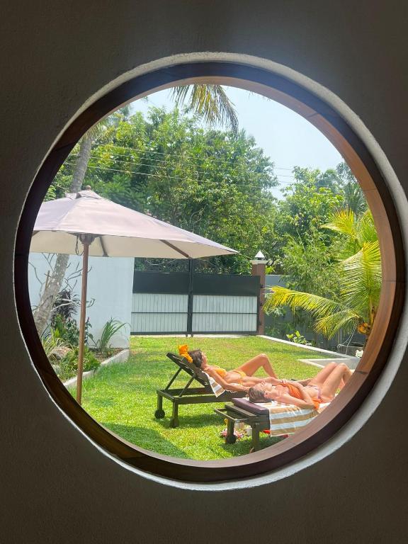 a couple of people laying on a chair in a yard at Ocean Life Ayurvedic Villa in Talalla South