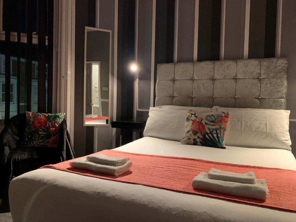 a bedroom with a bed with two towels on it at Coconut Cove in Blackpool