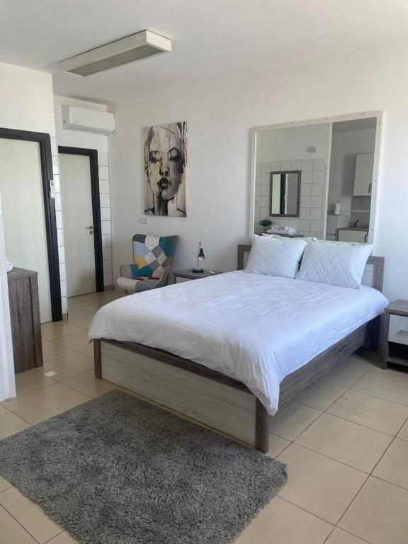 a bedroom with a large bed and a mirror at Seaside Studio in Larnaca
