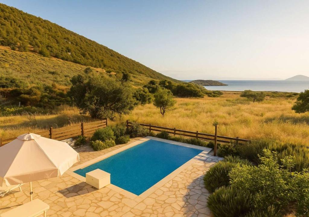 a swimming pool in front of a hill with the ocean at Seaside Aqua Bliss & Serenity with Private Pool in Kranidi