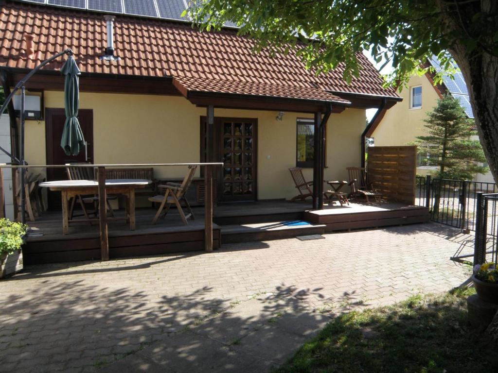 a house with a deck with a table and chairs at Haus Peeneblick in Freest