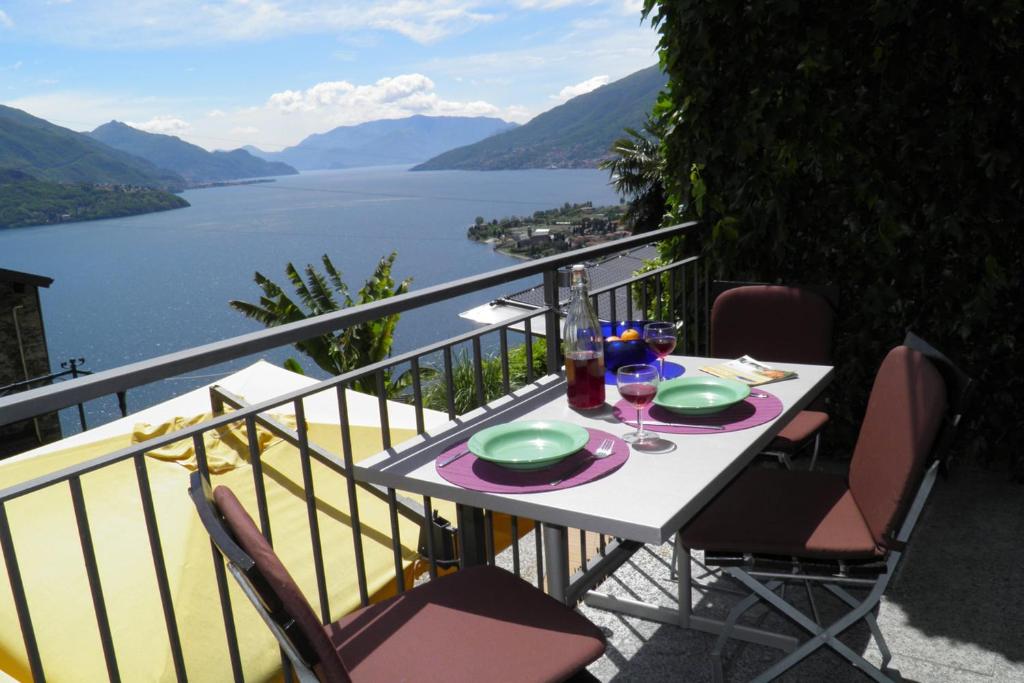 a table with plates and wine glasses on a balcony at Amarone Classica in Gravedona