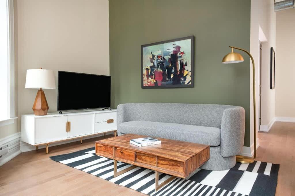 a living room with a couch and a tv at LIVN Millennium Park Downtown Chicago Superior 1BR in Chicago